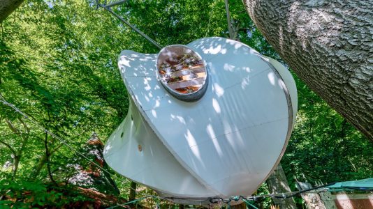 Die zwischen den Bäumen schwebende „Bücherwolke“ besteht aus einer Holzkonstruktion, die mit einer Kunststoffmembran umspannt ist. Foto: 360GRAD-TEAM GmbH